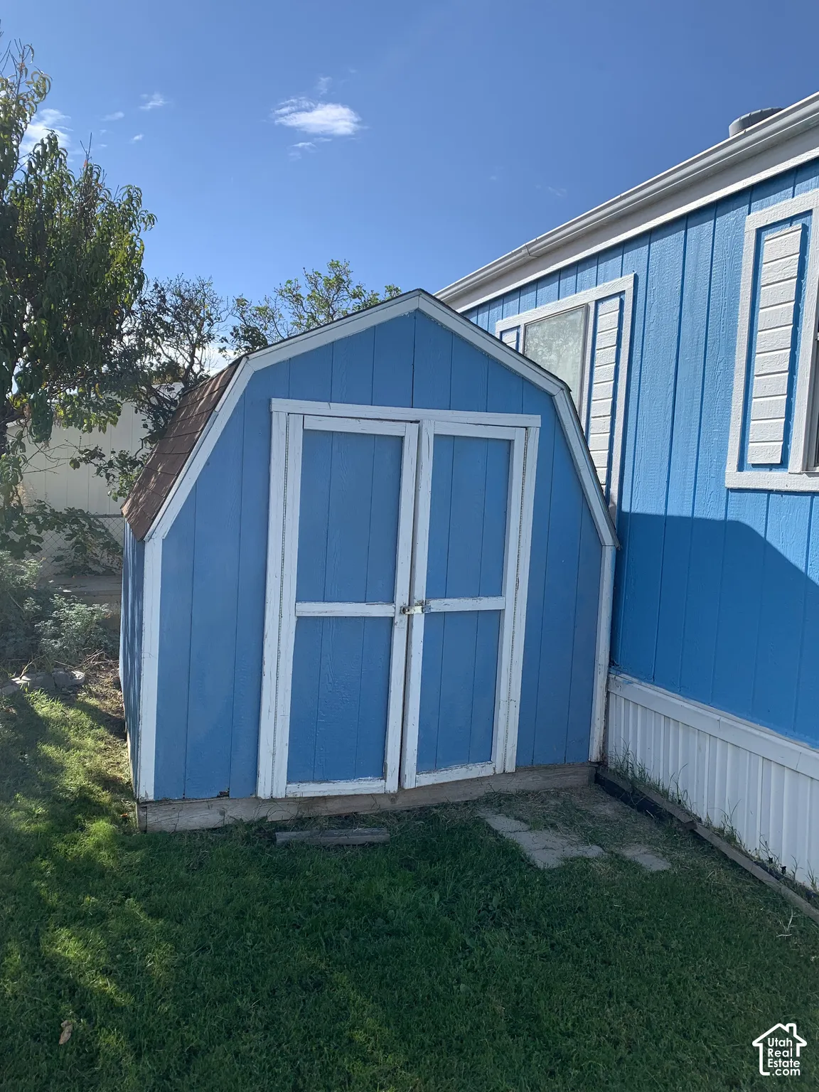 Barn-style exterior storage shed featuring dual entry doors and asphalt shingle roofing