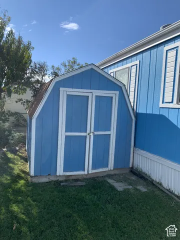 Barn-style exterior storage shed featuring dual entry doors and asphalt shingle roofing