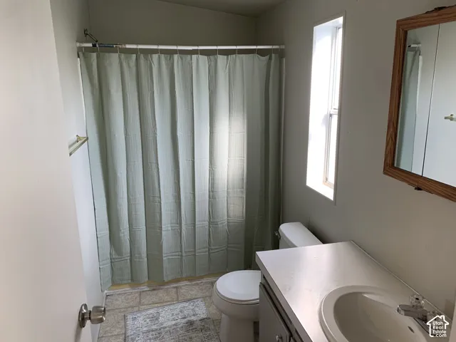 Master bathroom featuring a vanity with an integrated sink, a wall-mounted wooden frame mirror, and a tub-shower combination with a curtain rod