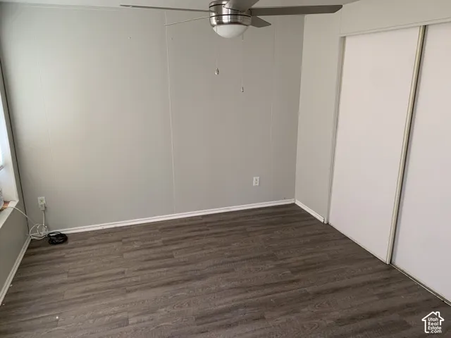 Master bedroom. Wood-finish flooring, neutral wall tones, sliding-door closet, and overhead ceiling fan with integrated lighting