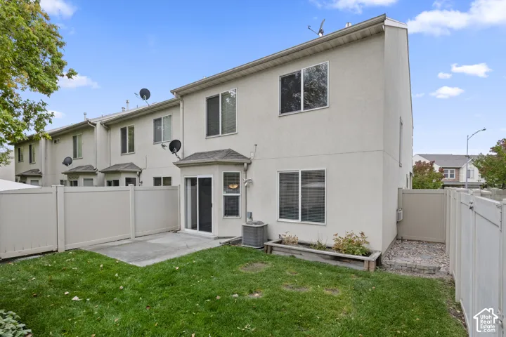 Exterior view featuring a stucco finish, private vinyl fencing, concrete patio, dedicated garden bed, and sliding glass door access