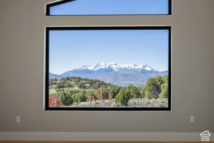 Large picture window with a geometric transom window, framing mountain scenery and natural landscape