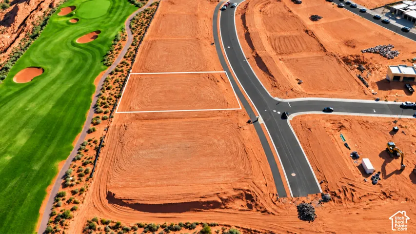 Vacant lot featuring paved street access, utility connection points, and direct proximity to a golf course