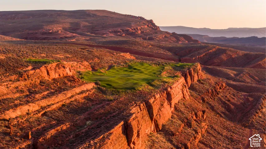 Golf course green situated on a sandstone mesa plateau surrounded by red rock canyon topography