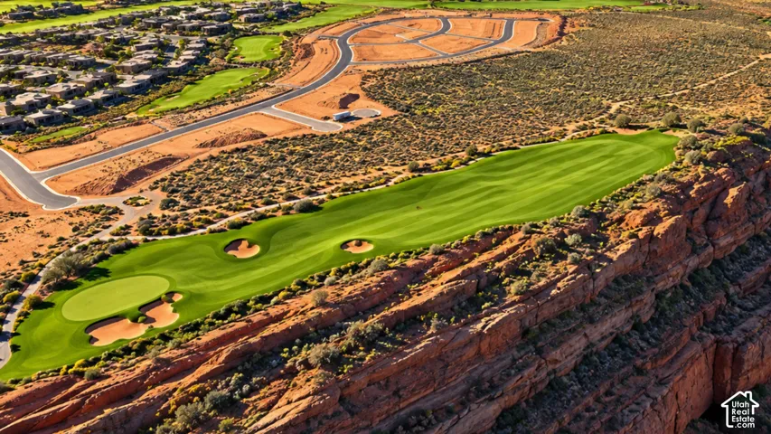Aerial perspective featuring a golf course, expansive sandstone rock formations, desert terrain, and paved infrastructure