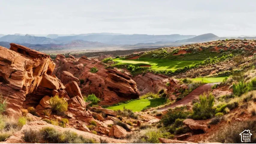 Natural red rock formations integrated with sculpted turf landscaping and expansive desert terrain