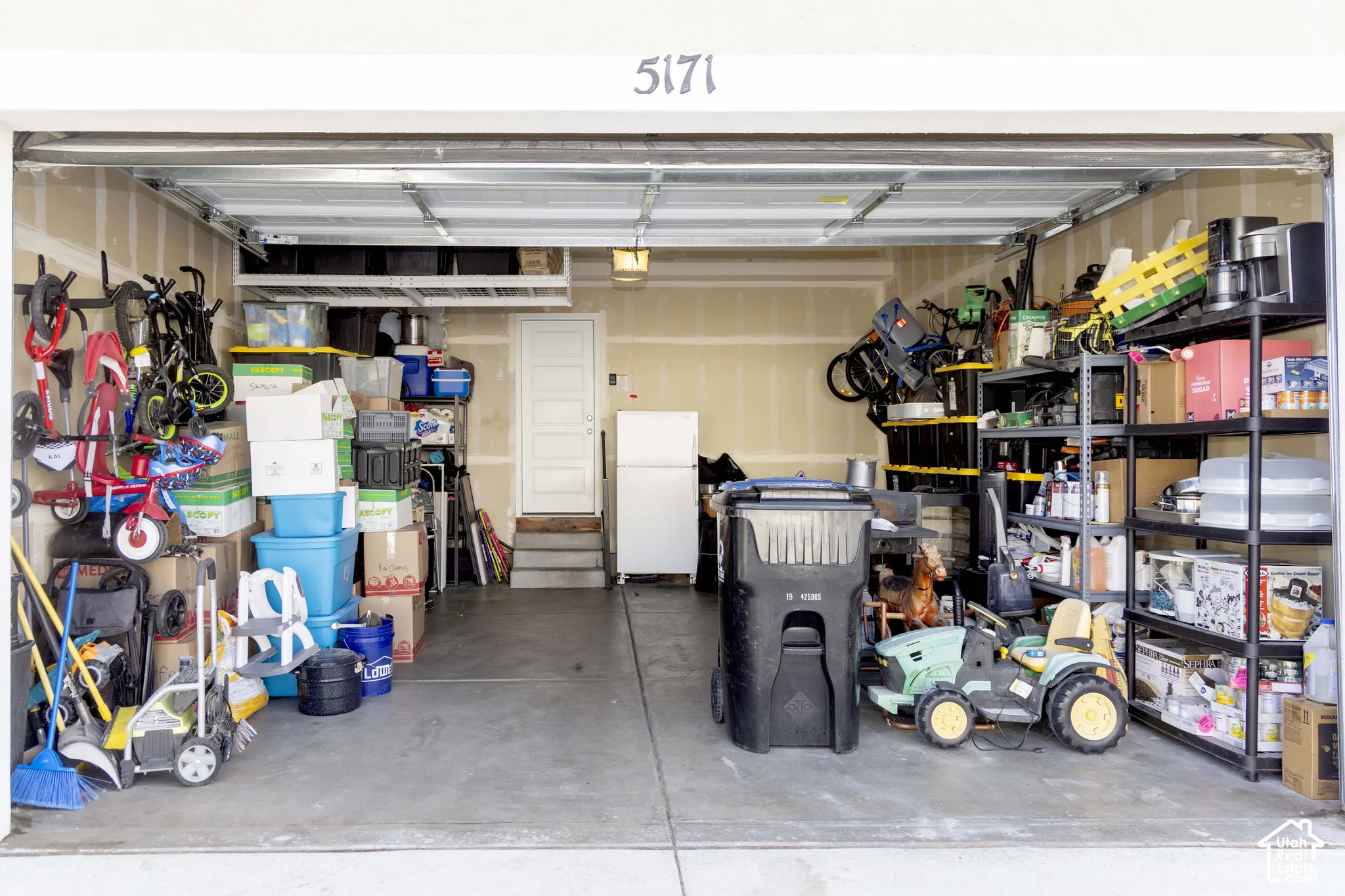 Attached 2-car garage featuring concrete flooring, overhead ceiling-mounted storage rack, and interior access door
