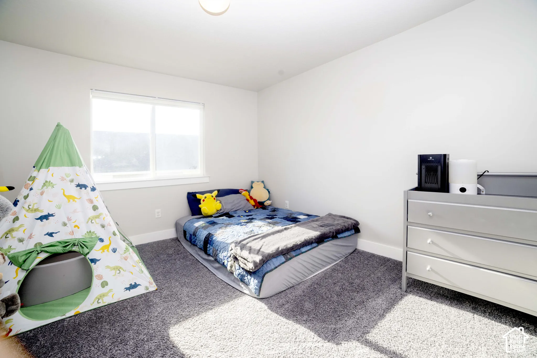 Neutral-toned bedroom featuring beige wall-to-wall carpeting and a single pane window