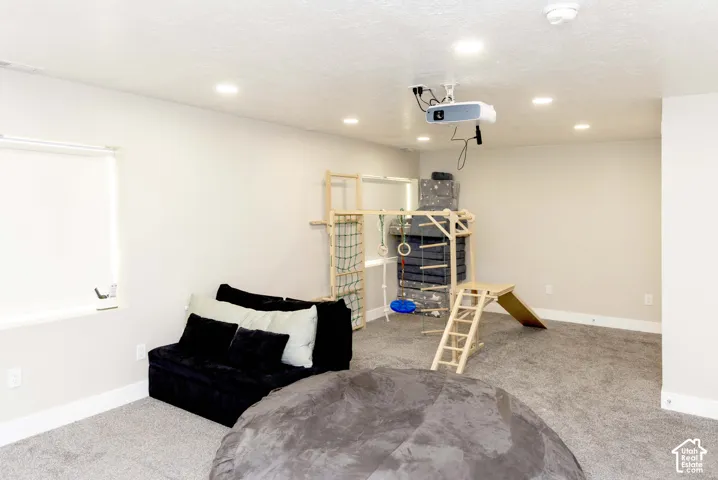 Interior room featuring neutral wall paint, recessed lighting, carpeted flooring, and a ceiling-mounted digital projector