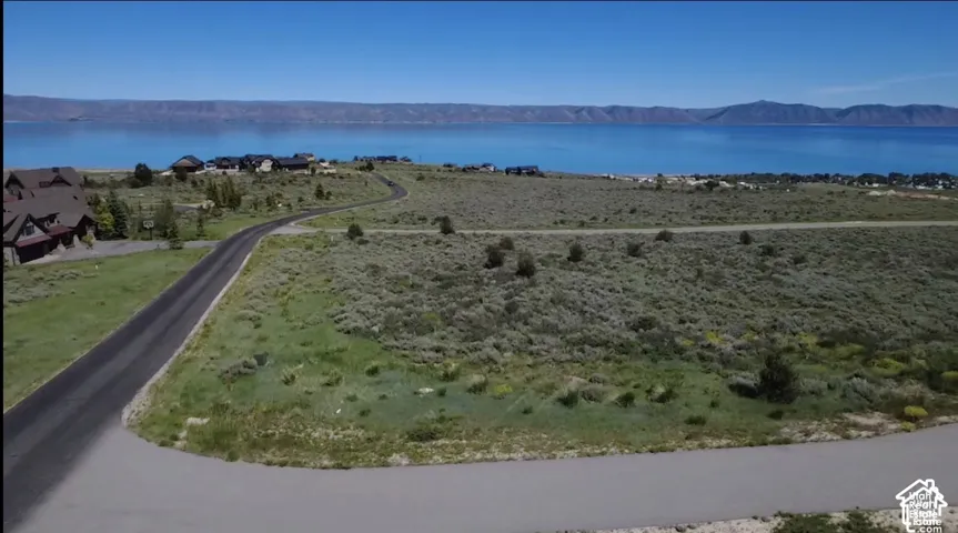 Expansive parcel featuring paved road access, native terrain, and panoramic water and mountain scenery