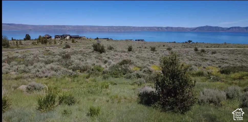 Expansive lot featuring native high-desert vegetation, prominent water frontage, and mountain backdrops