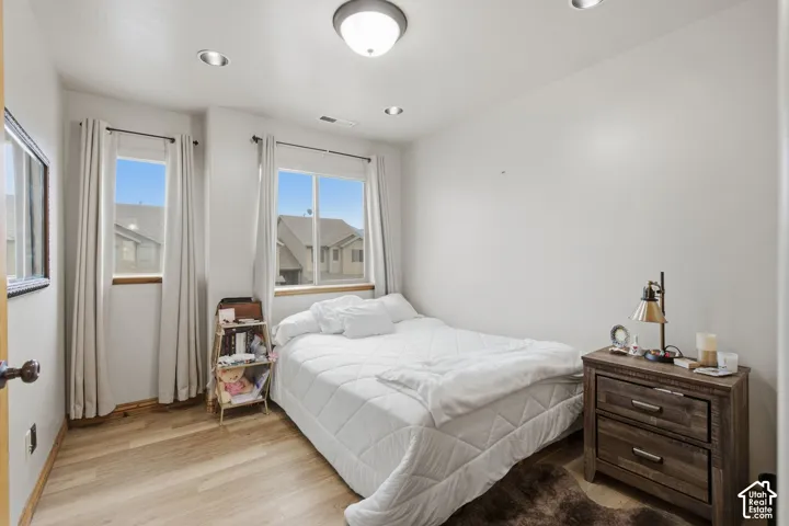 Wood-finish flooring, recessed lighting, and dual windows providing natural light