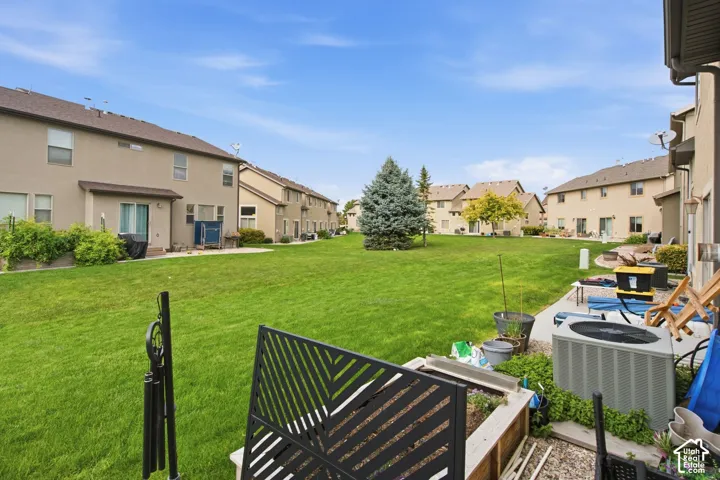 Expansive common green space with established landscaping and concrete patio areas