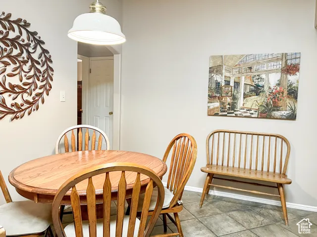 Neutral-toned walls featuring a dome-shaped pendant light and stone-finish tile flooring