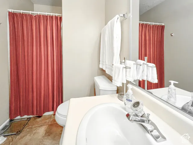 Vanity featuring an integrated sink, neutral countertop, and chrome faucet, paired with a full-width mirror and tile flooring