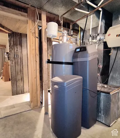 Mechanical area featuring a water heater, water softener system, and HVAC equipment with exposed wood framing