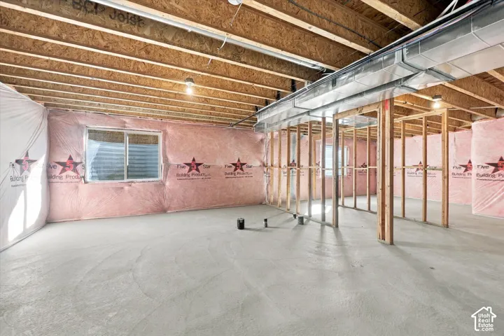Unfinished interior space featuring exposed wood joist ceilings, concrete flooring, insulated walls, and metal ductwork