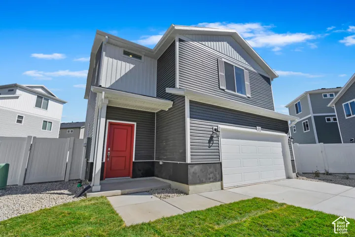 Two-story exterior featuring a mix of horizontal and vertical siding, a front-facing attached two-car garage, and a concrete driveway