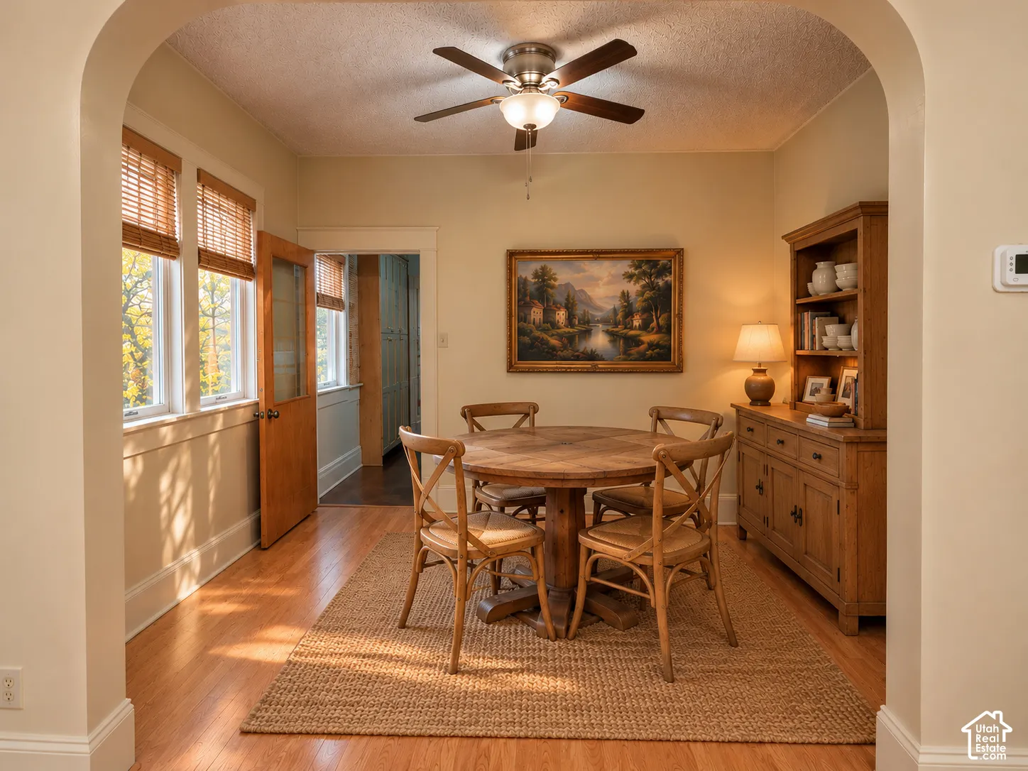 Arched entryway featuring wood-finish flooring, recessed multi-pane windows, and a ceiling-mounted light fixture with a fan