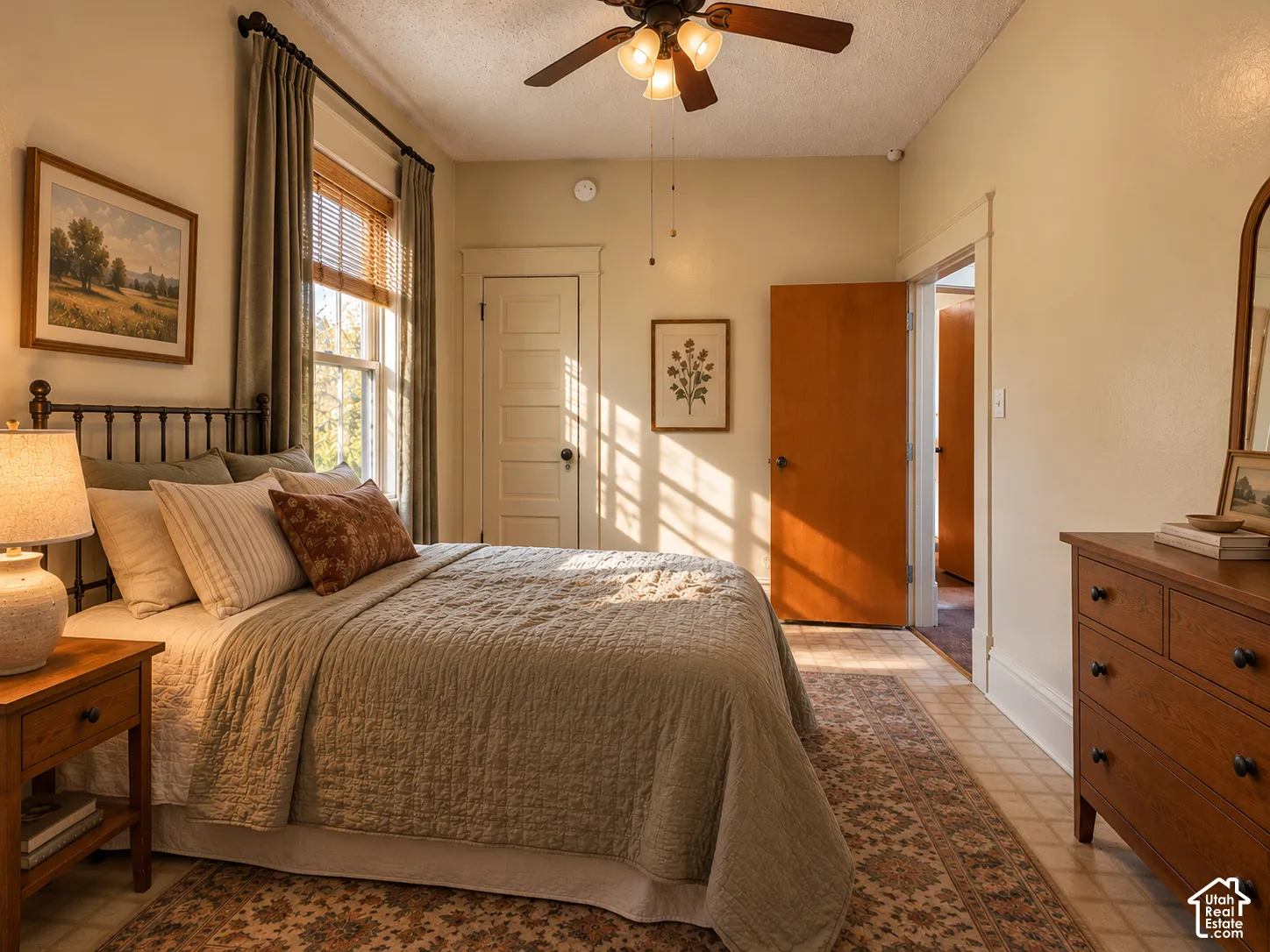 Interior room featuring multi-panel wood doors, high-profile door casing, a central ceiling fan with integrated lighting, and tile flooring
