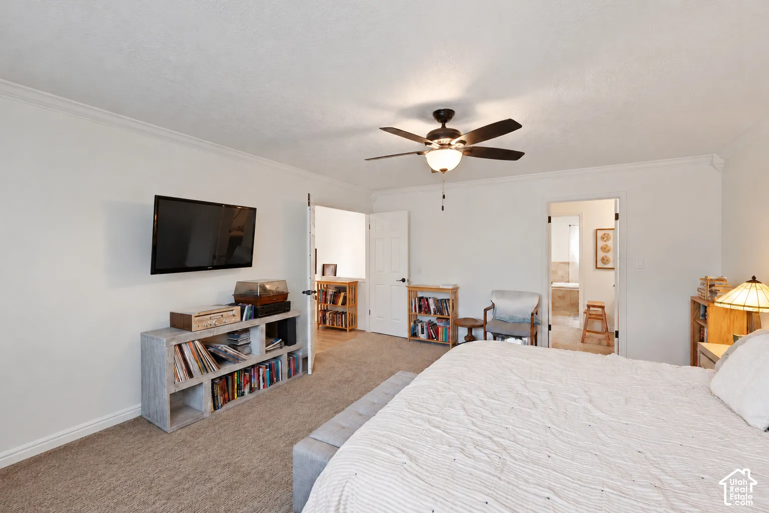 Neutral-toned carpet, ceiling fan with integrated light fixture, and paneled interior doors