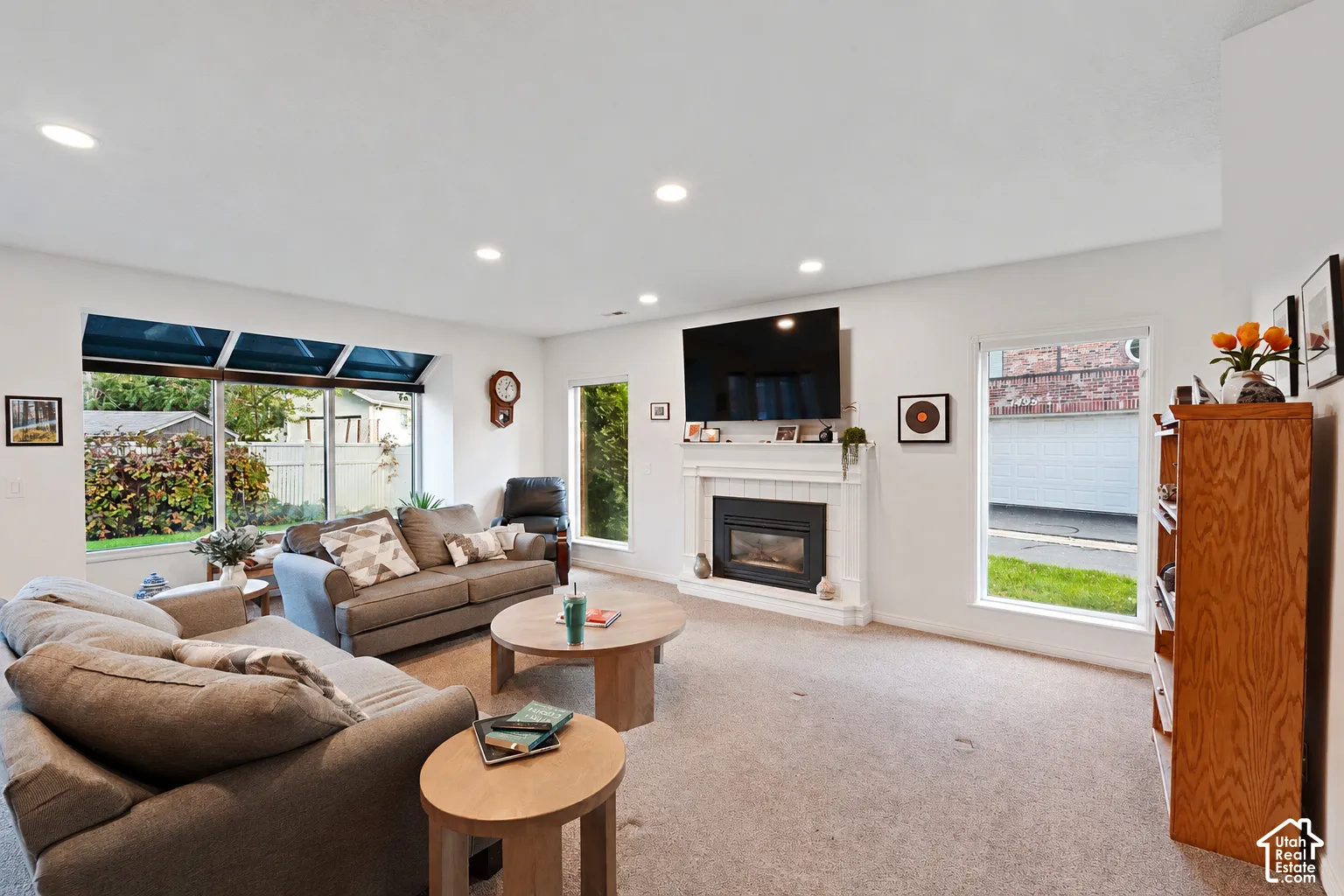 Living area featuring recessed lighting, a fireplace with a white mantel, and a multi-pane bay window