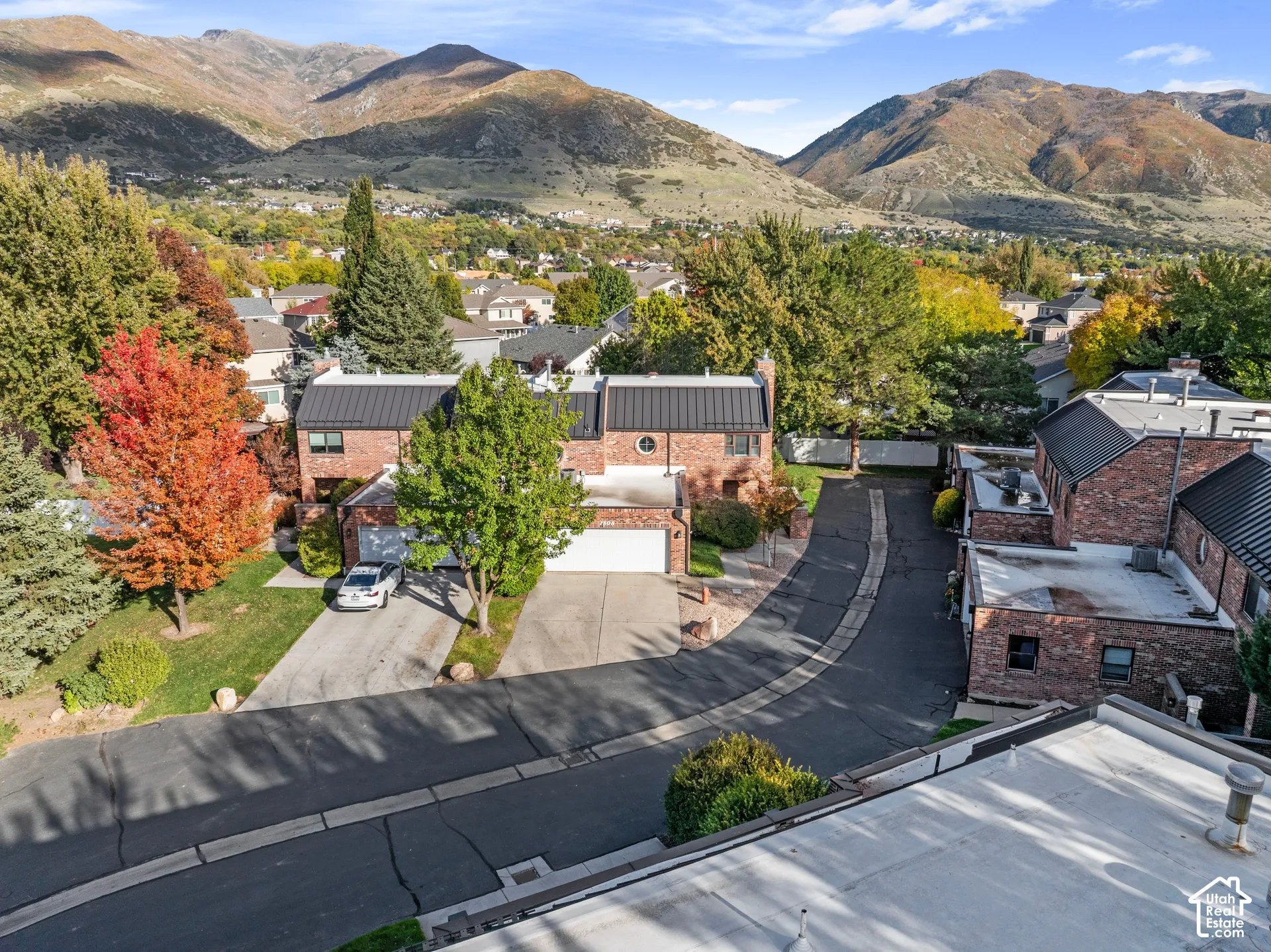 Brick exterior townhomes featuring metal roofing, private driveways, and expansive mountain scenery