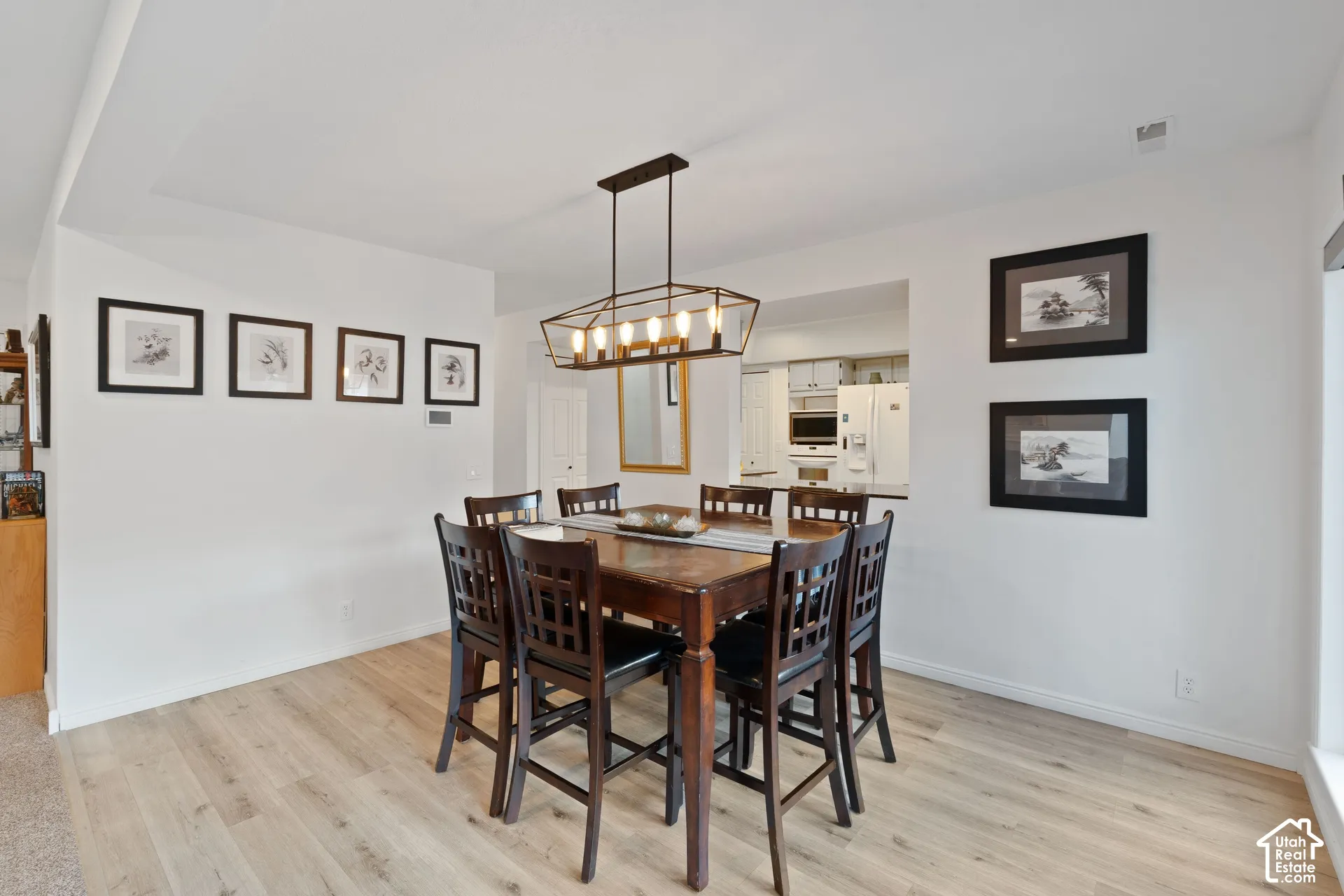 Dining space featuring wood-finish flooring, a tray ceiling, and a geometric multi-bulb hanging light fixture