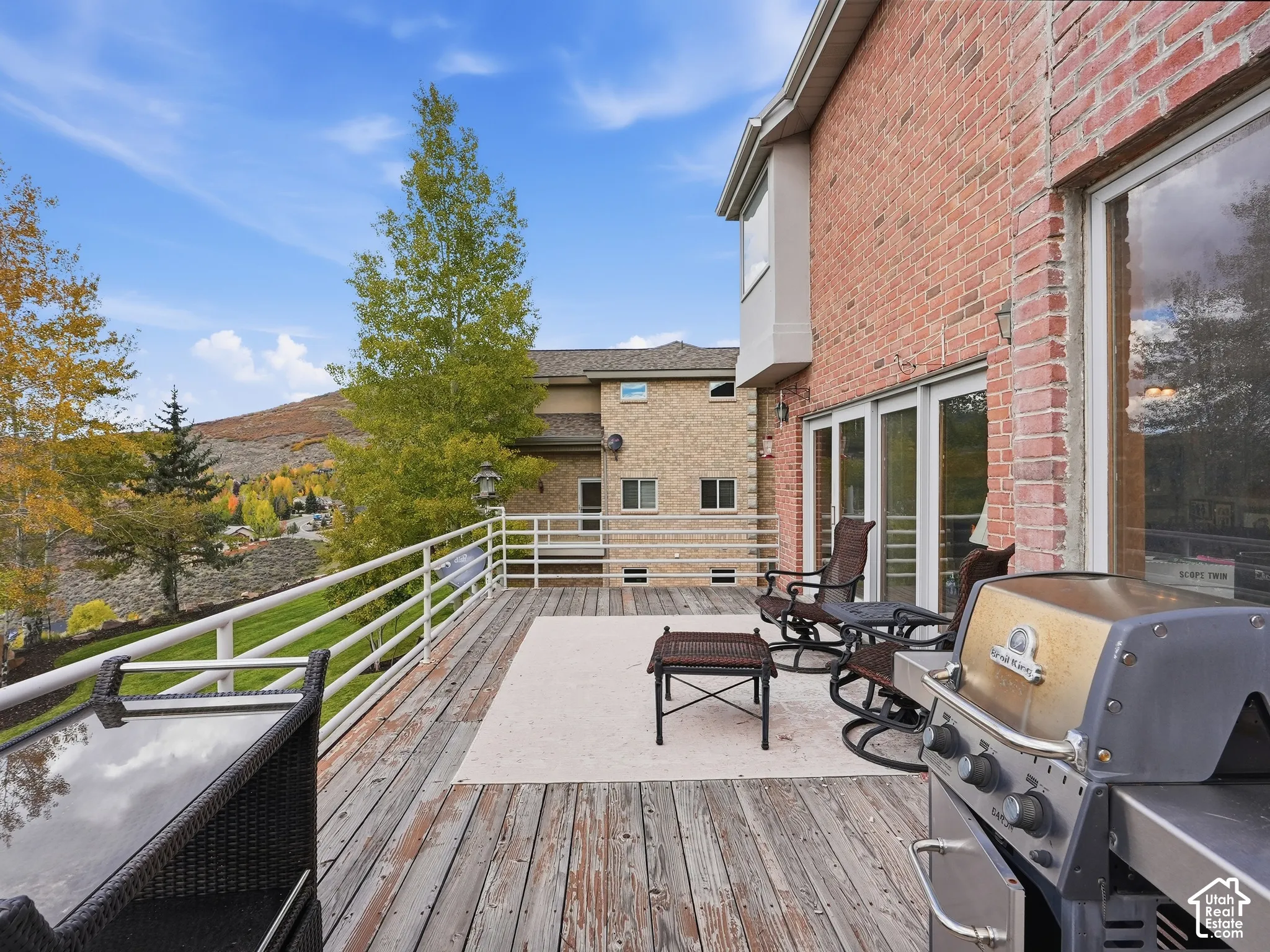 Elevated wood deck with white metal railings and expansive mountain scenery