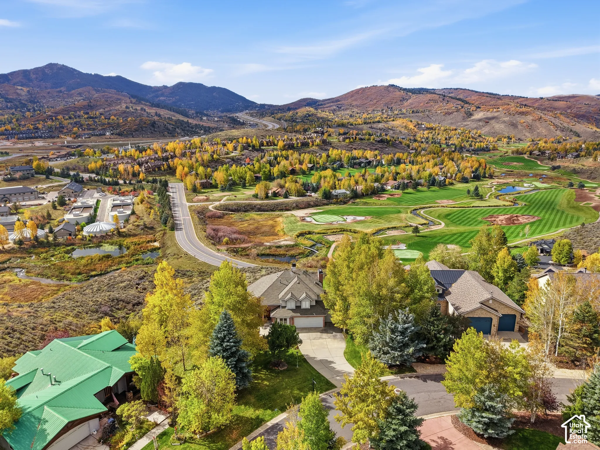 Aerial perspective featuring mountain terrain, mature tree canopy, and proximity to a golf course