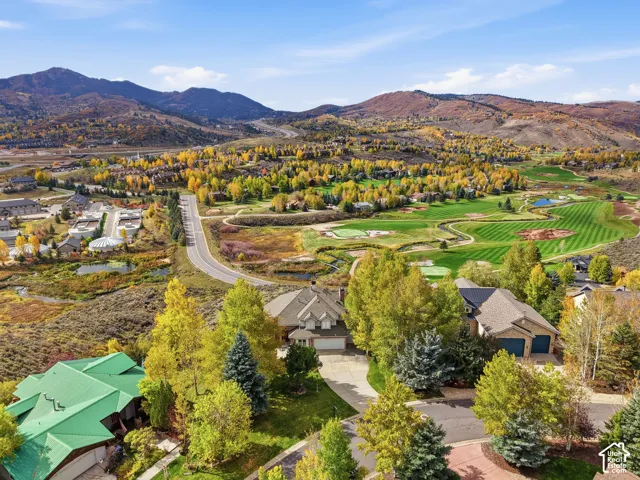 Aerial perspective featuring mountain terrain, mature tree canopy, and proximity to a golf course