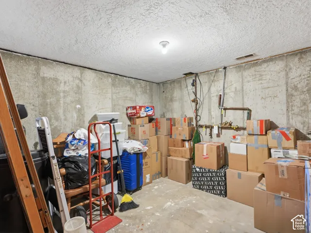 Unfinished storage area featuring exposed poured concrete foundation walls and concrete flooring