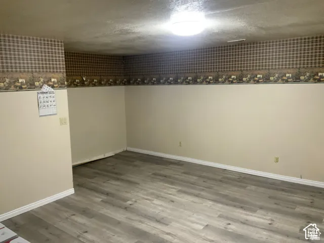Interior space featuring wood-finish flooring, neutral wall paint, and wallpaper border detailing