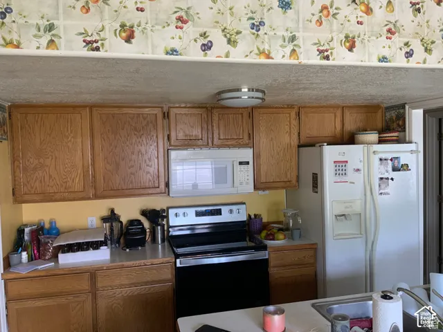 Kitchen featuring wood cabinetry, overhead microwave, stainless steel range, and flush-mount ceiling lighting