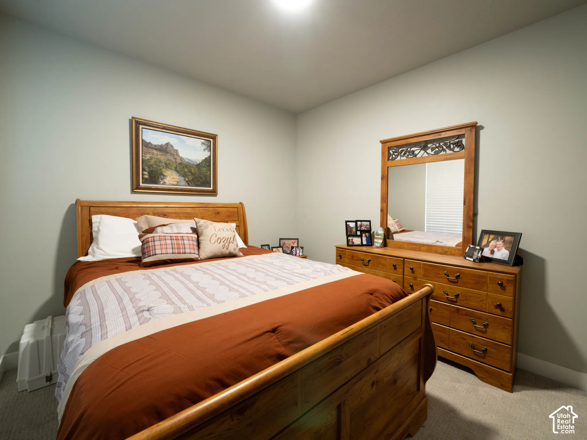 Recessed ceiling lighting illuminates a room with light gray wall paint and gray carpeting