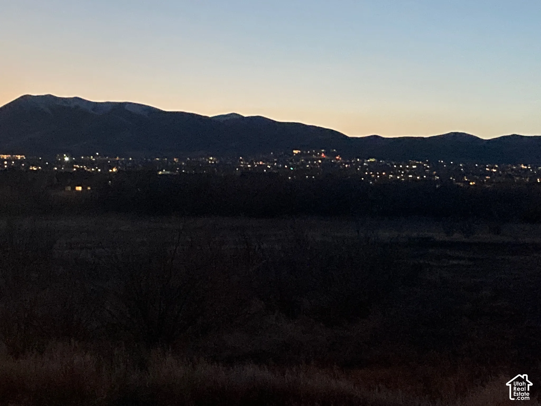 View from the backyard at night. Expansive mountain backdrop with ridgeline silhouettes and horizon-spanning terrain