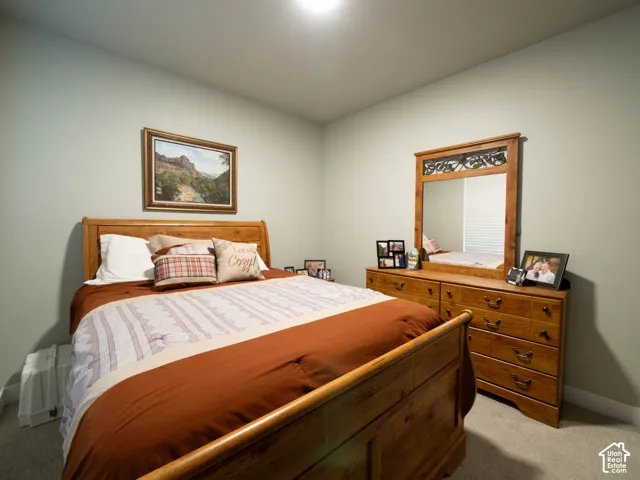 Recessed ceiling lighting illuminates a room with light gray wall paint and gray carpeting