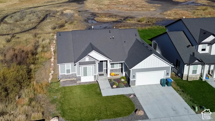 Gray siding exterior with white trim, dark shingle roof, and an attached two-car garage