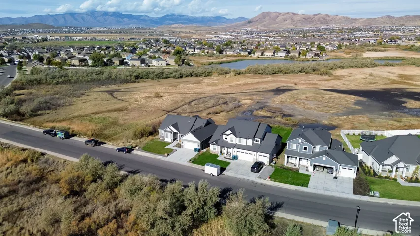 Newly constructed homes featuring a two-story design, dark pitched roofs, attached garages, and manicured front lawns