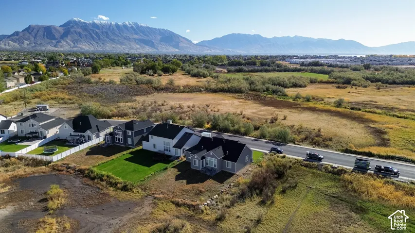 Mountain backdrop, residential street, manicured lawn, white fencing, varied home exteriors
