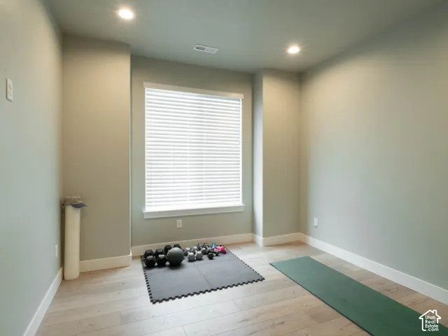 Recessed lighting, light wood-finish flooring, window with blinds, and painted walls