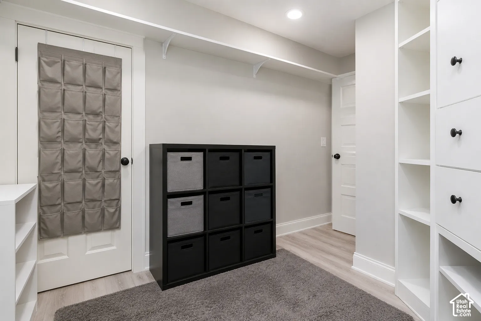 Built-in floor-to-ceiling cabinetry, recessed lighting, and wood-finish flooring