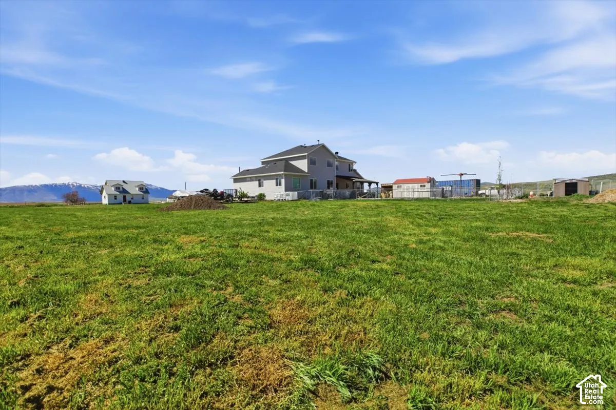 Expansive lot featuring open pasture space, two separate structures, and a mountain backdrop
