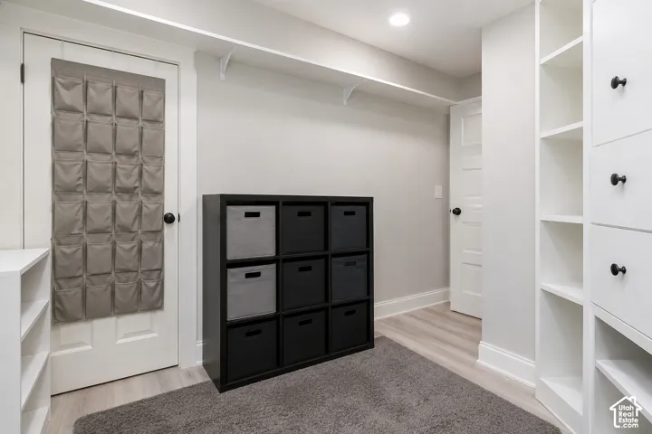 Built-in floor-to-ceiling cabinetry, recessed lighting, and wood-finish flooring