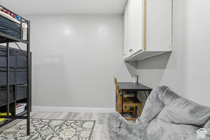 Room featuring wood-finish flooring and white wall-mounted cabinetry