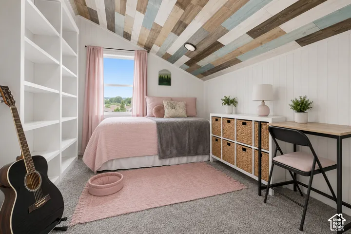 Sloped ceiling with multi-tone wood planking, white vertical paneling, floor-to-ceiling built-in white shelving, and a double-hung window