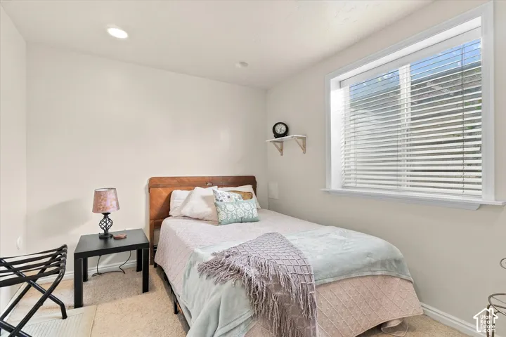 Neutral interior featuring recessed lighting, carpeting, and a large window with horizontal blinds