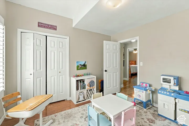 Room featuring wood-finish flooring, white paneled doors, dual-panel closet doors, and a ceiling-mounted light fixture