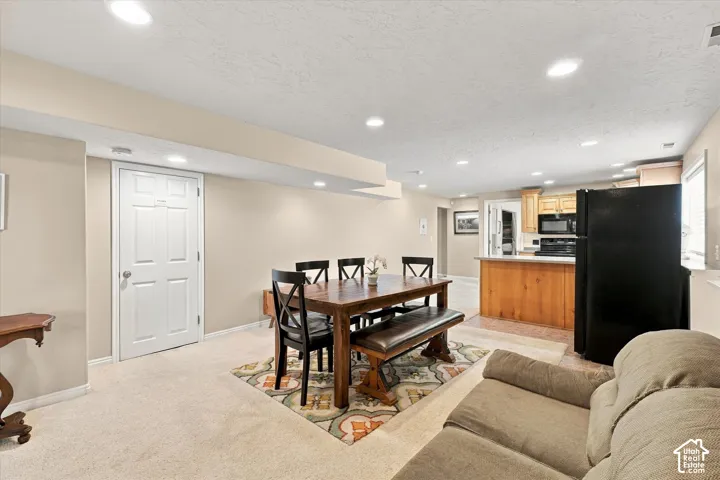 Open floor plan featuring recessed lighting, neutral wall palette, light carpeting, and a kitchen island with cabinetry