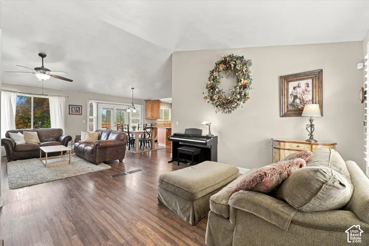 Vaulted ceilings, wood-finish flooring, and natural lighting provided by large windows and glass-paned doors